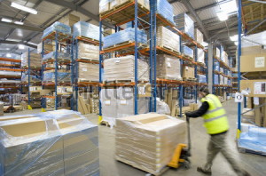 stock-photo-warehouse-worker-pushing-pallet-truck-with-cardboard-boxes-216580801